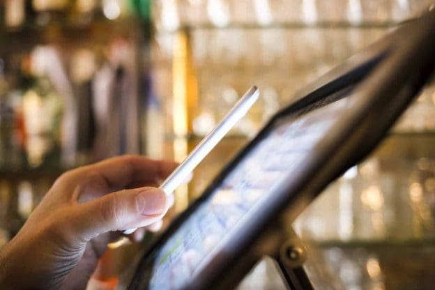 man paying with nfc technology on mobile phone in restaurant b 35345885