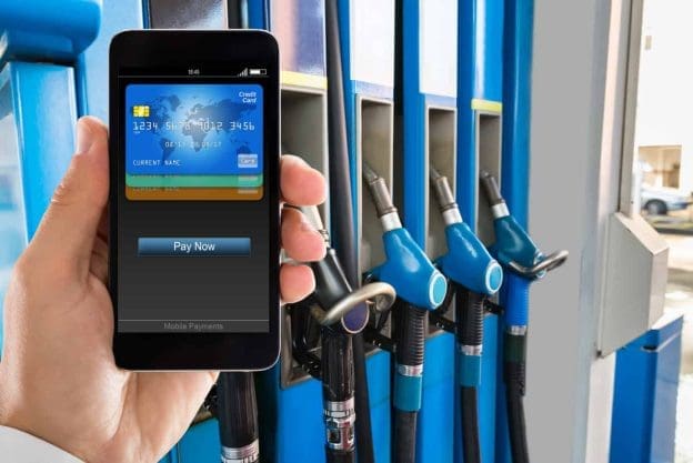 man paying with smartphone at gas station 124516558