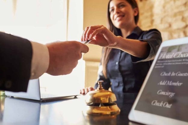 guest takes room key card at check in desk of hotel close up 71533469