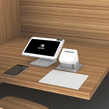 Contactless payment terminal with Clover POS system at modern checkout station.