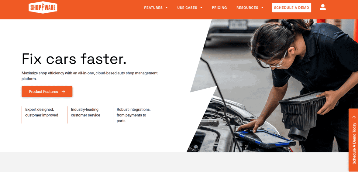Mobile auto shop repair technician using a payment device at vehicle engine bay.