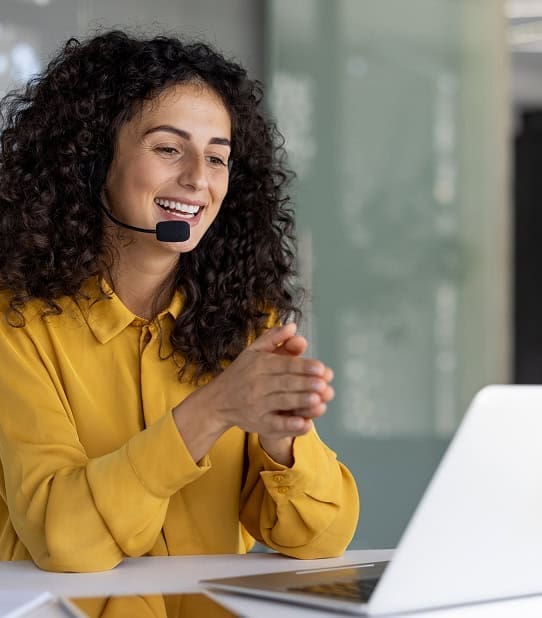 Happy customer support agent with headset assisting clients online for seamless payment processing and merchant services.