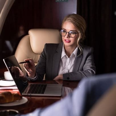 Businesswoman using mobile device for payment or communication at restaurant.