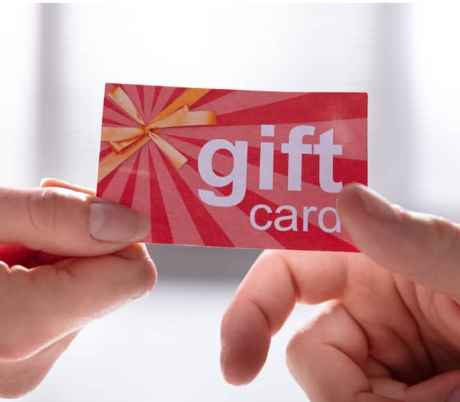 Gift card being handed over, photography of gift card, retail payment, and consumer gift transaction.
