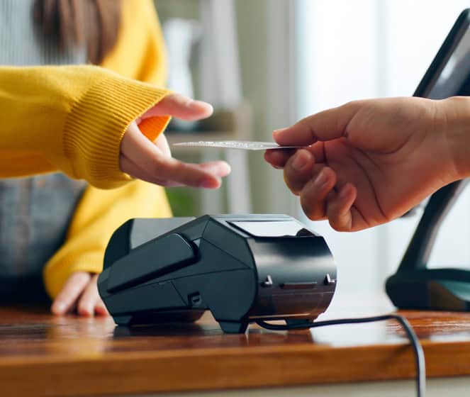 Contactless payment with card and POS terminal at retail store.