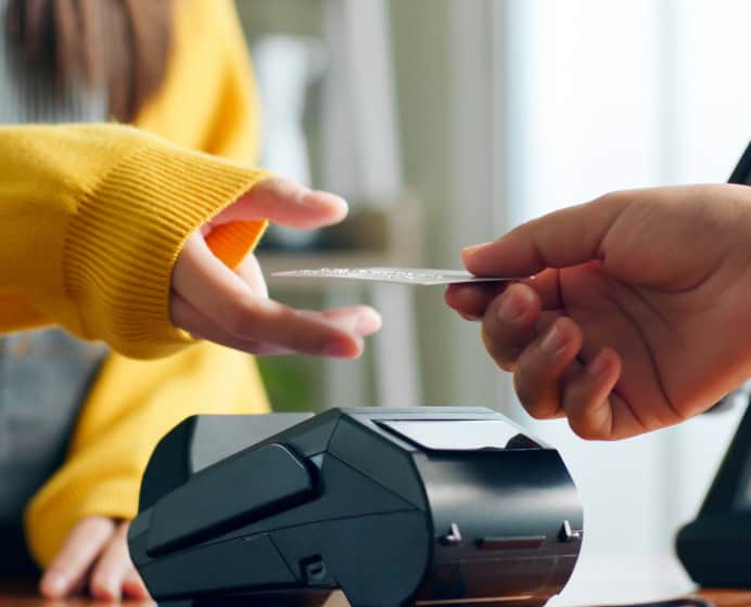 Contactless credit card payment at checkout with POS terminal.