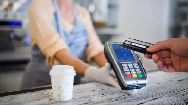 Contactless payment with credit card and POS terminal at a merchant.