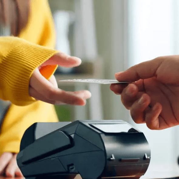 Contactless credit card payment at checkout with POS terminal.