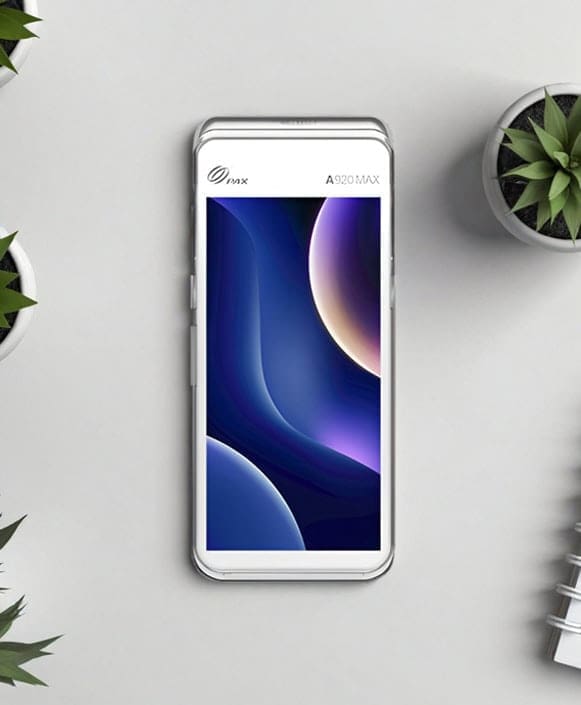 Smartphone with sleek design on a light desk, surrounded by plants, showcasing modern payment technology.