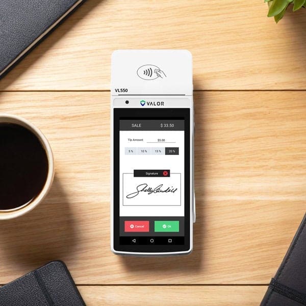 Contactless payment terminal for Host Merchant Services on wooden desk.